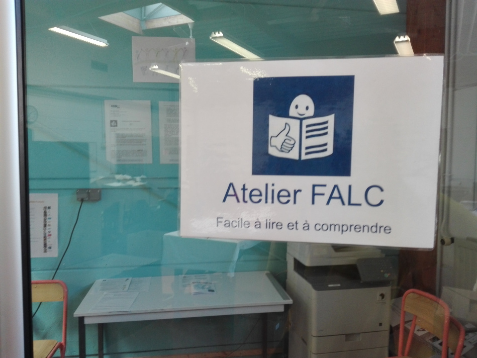 Glastür ins FALC-Büro. Darauf kleb ein A4-Blatt mit dem Logo der Leichten Sprache